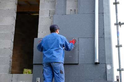 Pose de panneaux isolants sur une façade en cours d’isolation par l’extérieur