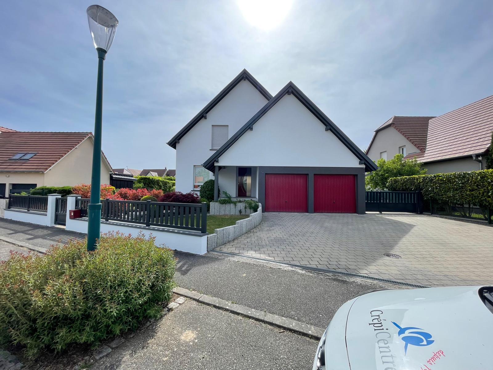 Façadier appliquant un enduit de finition sur une façade en cours de ravalement en Alsace