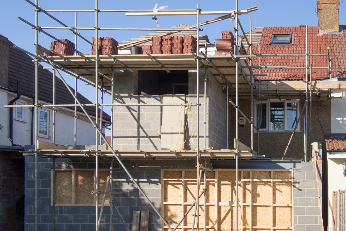 Agrandissement d'une maison avec façade en crépi clair, exemple de projet soumis à déclaration préalable ou permis de construire