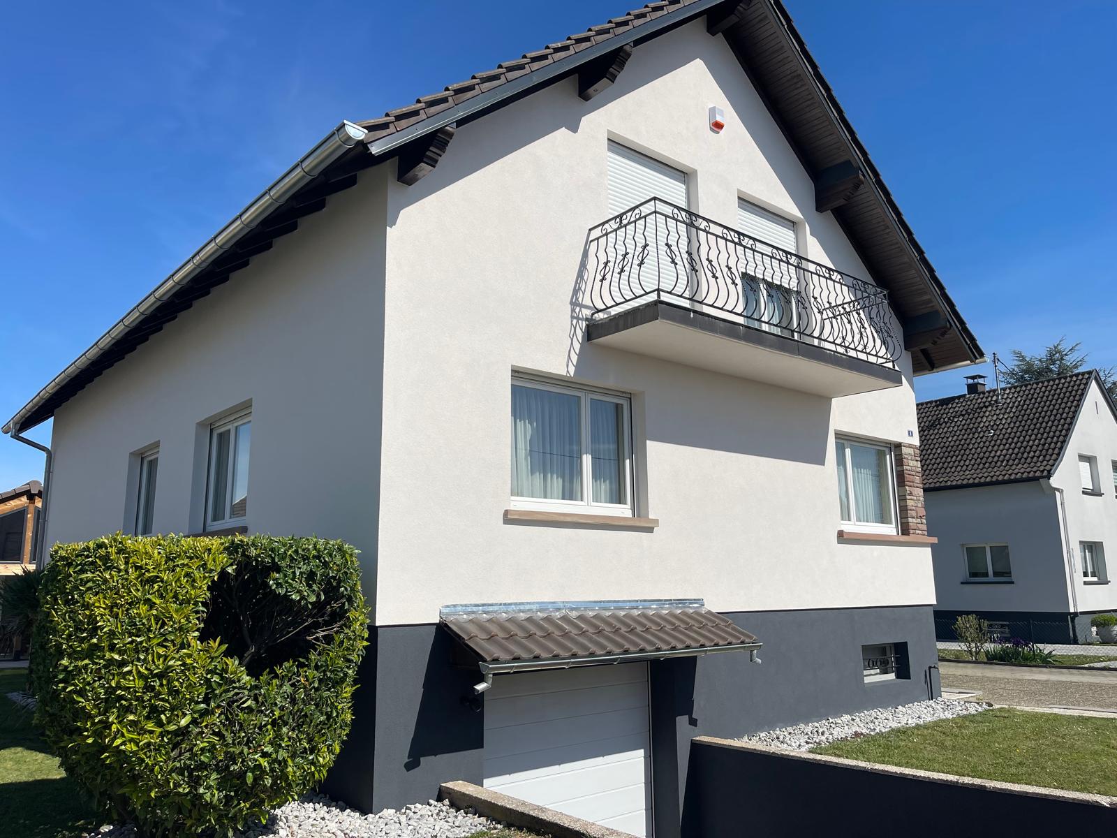 Fissure dans l'enduit d'une façade de maison, observée de près pour en évaluer la largeur
